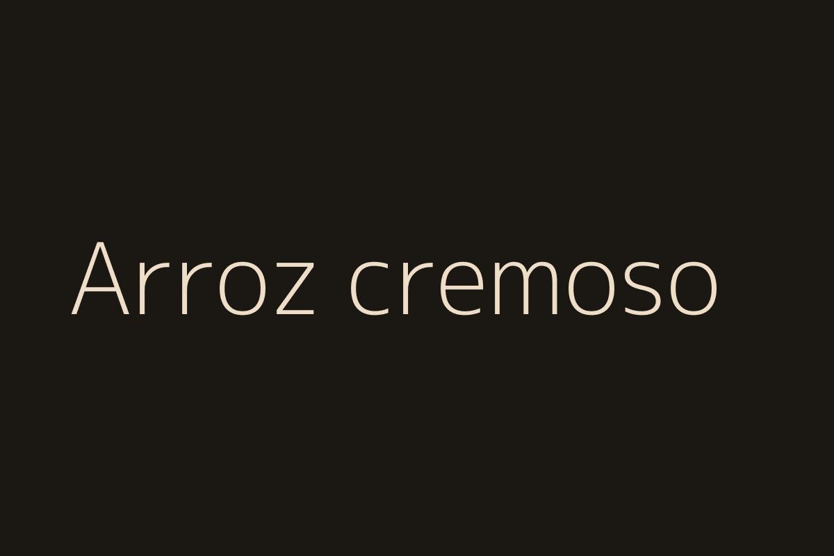 Primer plano del arroz cremoso con espinacas, luz cálida.