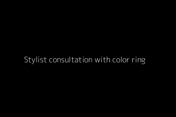 A stylist performing a professional hair consultation, pointing to a color ring and scalp area.