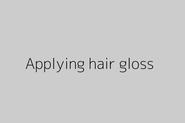 Close-up of hands applying a conditioning gloss to damp hair in the shower.