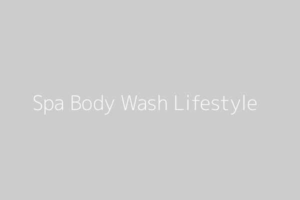 A serene bathroom scene with natural light, leafy plants, and a bottle of body wash on a wooden tray, evoking a spa-like, aromatic experience.